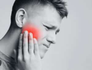 The image may portray the temporomandibular joint (TMJ) and associated discomfort, emphasizing the source of jaw pain.