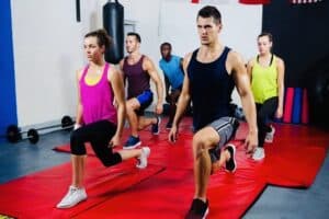 A diverse group of people, fitness levels, smiling and exercising together in a fitness class, showcasing the social and motivational aspects of HIIT workouts.
